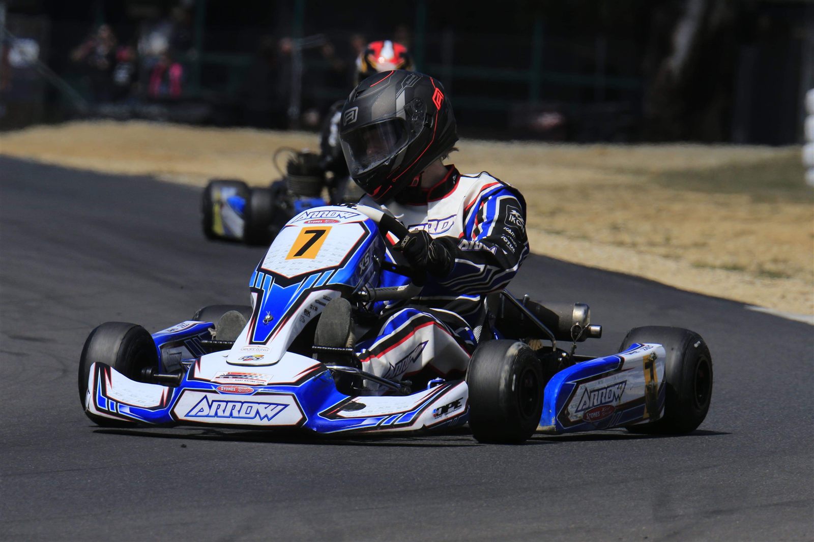 Tasman Reedie racing kart number 7, a blue and white Arrow, through a corner